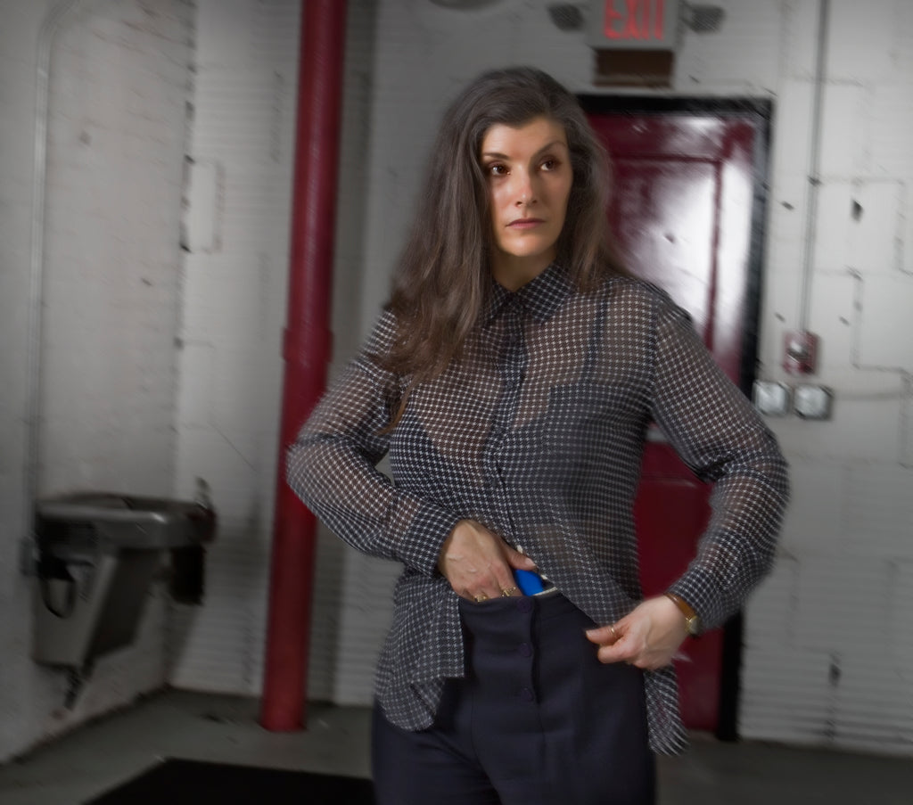 Female drawing concealed firearm in an industrial setting